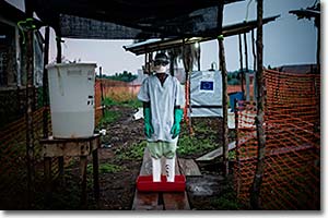 Higienista descontaminando sus botas en el centro de tratamiento de ébola en Boende. Los procedimientos de higiene dentro de los centros son muy estrictos para prevenir posibles infecciones en el interior de las instalaciones.