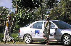 Mujeres cargadas con hojas de t pasan junto al coche en una carretera al norte de la India.